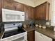 White appliances and dark wood cabinets in this kitchen at 14226 W Via Montoya --, Sun City West, AZ 85375