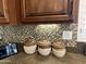 Kitchen backsplash with a mosaic tile pattern and wood cabinets at 14226 W Via Montoya --, Sun City West, AZ 85375