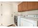 Bright laundry room with washer, dryer, and cabinets at 14400 N 136Th Ln, Surprise, AZ 85379