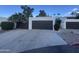 Attached two-car garage with modern door and a long driveway with desert landscape at 1501 S River Dr, Tempe, AZ 85281