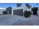 Spacious two-car garage featuring a private driveway and beautiful desert landscaping at 1501 S River Dr, Tempe, AZ 85281