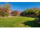 Landscaped backyard with green lawn and vibrant flowers at 17353 N 99Th St, Scottsdale, AZ 85255