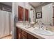 Double vanity bathroom with wood cabinets and a shower/tub combo at 17353 N 99Th St, Scottsdale, AZ 85255