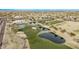 Aerial view showing a golf course, clubhouse, and ponds at 17802 N Bridle Ln, Surprise, AZ 85374