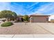 Tan house with a two-car garage and gravel landscaping at 17802 N Bridle Ln, Surprise, AZ 85374