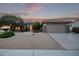 Tan colored house with a two-car garage and gravel landscaping at 17802 N Bridle Ln, Surprise, AZ 85374