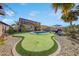 Landscaped backyard oasis with a pool and putting green at 17842 W Chuckwalla Canyon Rd, Goodyear, AZ 85338