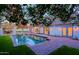 Relaxing backyard with a sparkling pool, covered patio, and lush green lawn at 18 W Kaler Dr, Phoenix, AZ 85021