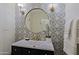 Elegant bathroom featuring a round mirror, decorative wallpaper, and modern fixtures at 18 W Kaler Dr, Phoenix, AZ 85021