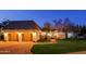 Exterior evening view of the home, with brick driveway and two-car garage with carriage doors at 18 W Kaler Dr, Phoenix, AZ 85021