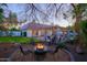 Cozy backyard with a firepit, lounge area, and a covered patio next to mature shade trees at 18 W Kaler Dr, Phoenix, AZ 85021