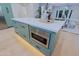 Kitchen island featuring sage cabinets, stainless steel microwave, and a quartz countertop at 18 W Kaler Dr, Phoenix, AZ 85021