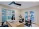 Well-lit office with plantation shutters, French doors to the patio, and a modern ceiling fan at 18 W Kaler Dr, Phoenix, AZ 85021