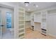 Open walk-in closet providing ample space with built-in shelving, hanging racks, and natural light from glass block window at 18 W Kaler Dr, Phoenix, AZ 85021