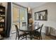 Dining area with a wood table, four chairs, a sliding glass door to the balcony, and a modern light fixture at 18250 N Cave Creek Rd # 180, Phoenix, AZ 85032