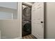 Convenient laundry area with full-size, stacked washer and dryer and white doors at 18250 N Cave Creek Rd # 180, Phoenix, AZ 85032