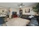 Living room features a ceiling fan, black leather sectional, television, and view of the kitchen at 18250 N Cave Creek Rd # 180, Phoenix, AZ 85032