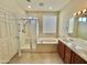 Bathroom with double sinks, soaking tub, and walk-in shower at 18328 N Avalon Ln, Surprise, AZ 85374