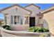 Tan two-story house with a large window and landscaping at 18328 N Avalon Ln, Surprise, AZ 85374