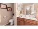 Bathroom with single vanity, toilet, and wood cabinets at 19601 N Krupps Ct, Maricopa, AZ 85138