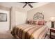 Cozy bedroom with striped bedding and a ceiling fan at 19601 N Krupps Ct, Maricopa, AZ 85138