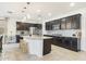 Kitchen featuring an island with bar stool seating, granite countertops, and dark cabinets at 2022 W Briana Way, Queen Creek, AZ 85144