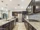 Kitchen with stainless steel appliances, an island with granite countertop, and dark wood cabinets at 2022 W Briana Way, Queen Creek, AZ 85144