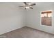 Bright bedroom with neutral walls and carpet, featuring a ceiling fan and window at 20967 N 96Th Ln, Peoria, AZ 85382