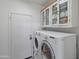 Laundry room with washer, dryer, and overhead cabinets at 20967 N 96Th Ln, Peoria, AZ 85382