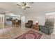 Open living room and kitchen with tile floors and ceiling fan at 20967 N 96Th Ln, Peoria, AZ 85382