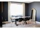 Dining room with a dark-colored wall, a wooden table, and black chairs at 21282 E Swan Dr, Queen Creek, AZ 85142