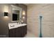 Contemporary bathroom with a sleek vanity, decorative wall lighting, textured wall tile, and quartz countertop at 25150 N Windy Walk Dr # 11, Scottsdale, AZ 85255