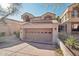 Attached garage with a tan door and driveway at 25150 N Windy Walk Dr # 11, Scottsdale, AZ 85255