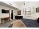 Stylish main bedroom with modern desk area, art features, and bright natural light from shuttered windows at 25150 N Windy Walk Dr # 11, Scottsdale, AZ 85255