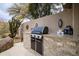 Built-in outdoor kitchen with grill and granite countertop at 25150 N Windy Walk Dr # 11, Scottsdale, AZ 85255