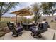 Relaxing patio with fire pit, comfortable seating, and shade umbrella at 25150 N Windy Walk Dr # 11, Scottsdale, AZ 85255