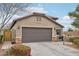 House exterior showcasing a two-car garage and nicely landscaped front yard at 27573 N 174Th Dr, Surprise, AZ 85387