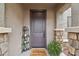 Inviting entryway with a dark brown door and welcome mat at 27573 N 174Th Dr, Surprise, AZ 85387