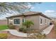 Tan house with brown roof, landscaped yard, and a walkway at 27573 N 174Th Dr, Surprise, AZ 85387