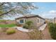 Tan house with brown roof, landscaped yard, and a walkway at 27573 N 174Th Dr, Surprise, AZ 85387