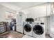 Functional laundry room with white washer and dryer, refrigerator, and ample storage space at 2808 N Granite Reef Rd, Scottsdale, AZ 85257