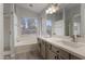 Well-lit bathroom featuring a dual sink vanity, bathtub, separate shower, and large window for natural light at 2830 S Arroyo Ct, Chandler, AZ 85286