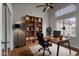 A home office featuring a hardwood floor, a large bookshelf, a desk, and a window with natural light at 2830 S Arroyo Ct, Chandler, AZ 85286