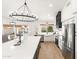 Open concept kitchen with white cabinets and a statement chandelier at 29840 N 43Rd Way, Cave Creek, AZ 85331