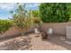 Seating area in a private backyard with decorative trees and a block fence at 3501 E Apricot Ln, Gilbert, AZ 85298