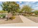 Scenic view of the The Bridges at Gilbert community park showcasing a pond, walkway, and playground area at 3501 E Apricot Ln, Gilbert, AZ 85298