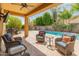 Covered patio with comfortable seating, a BBQ, and views of the refreshing pool at 3501 E Apricot Ln, Gilbert, AZ 85298