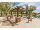 Community picnic area with shade structure, stone pillars, and a grill, near the water at 3501 E Apricot Ln, Gilbert, AZ 85298