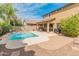 Backyard view with a large pool, covered patio, and manicured landscaping at 3501 E Apricot Ln, Gilbert, AZ 85298