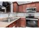 Kitchen with double sink, wood cabinets, and stainless steel appliances at 3621 W Glass Ln, Phoenix, AZ 85041